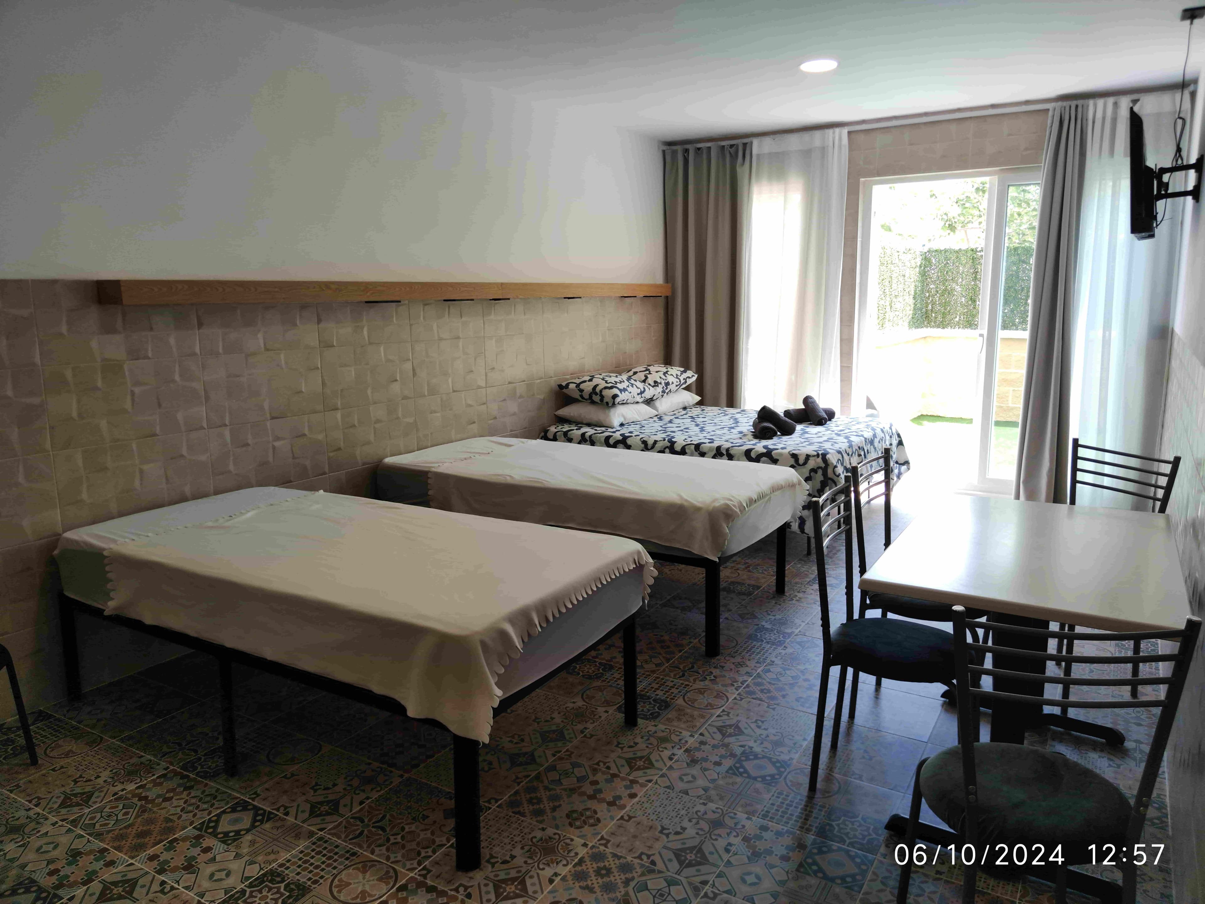 The same La Ruta quadruple studio from the doorway, the two single beds in front of the double bed and the garden doors beyond