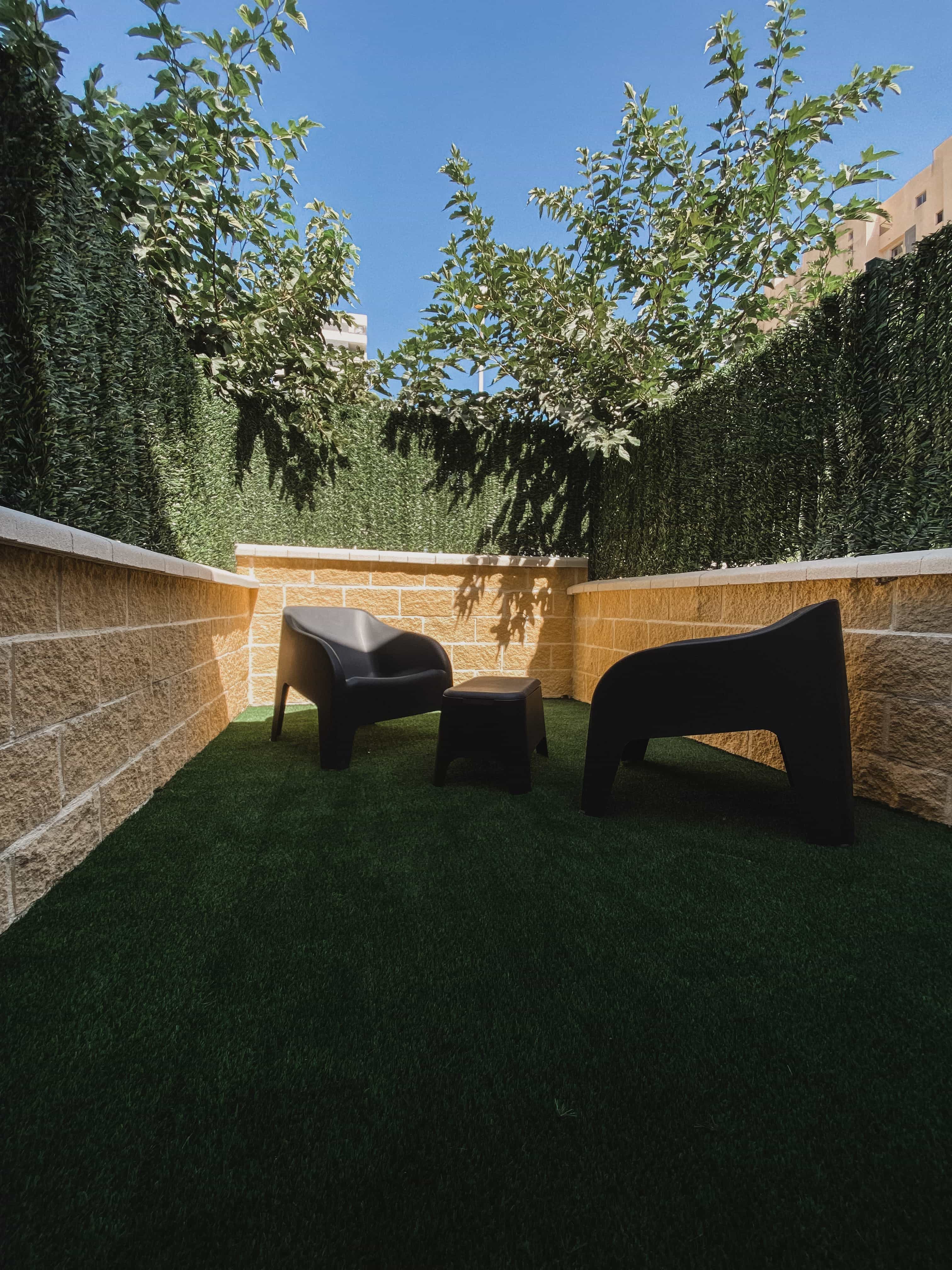 Sunlit private patio with seating at Apartamentos La Ruta