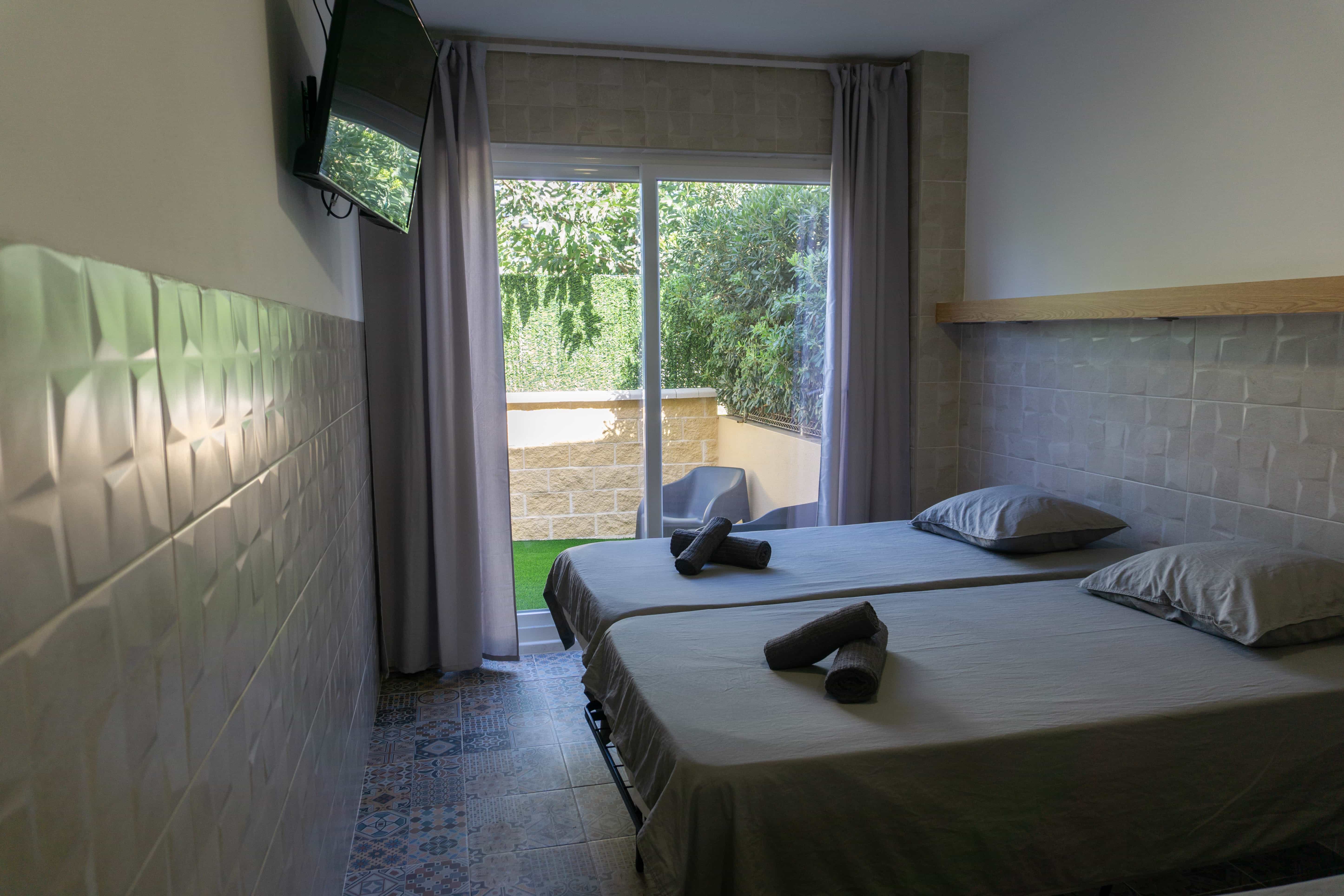 Bedroom with glass doors leading to balcony at Apartamentos La Ruta